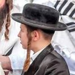 A picture of a modern Jewish man wearing a cap and sideburn braids